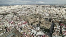 City view of Seville with impressive Seville Cathedral; wide drone pan