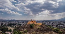 aerial shot showcases a stunning hilltop church with striking golden domes and twin spires, exuding an air of historical reverence and architectural splendor in Mexico