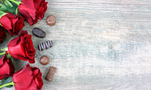 chocolates and red roses on a wood background 