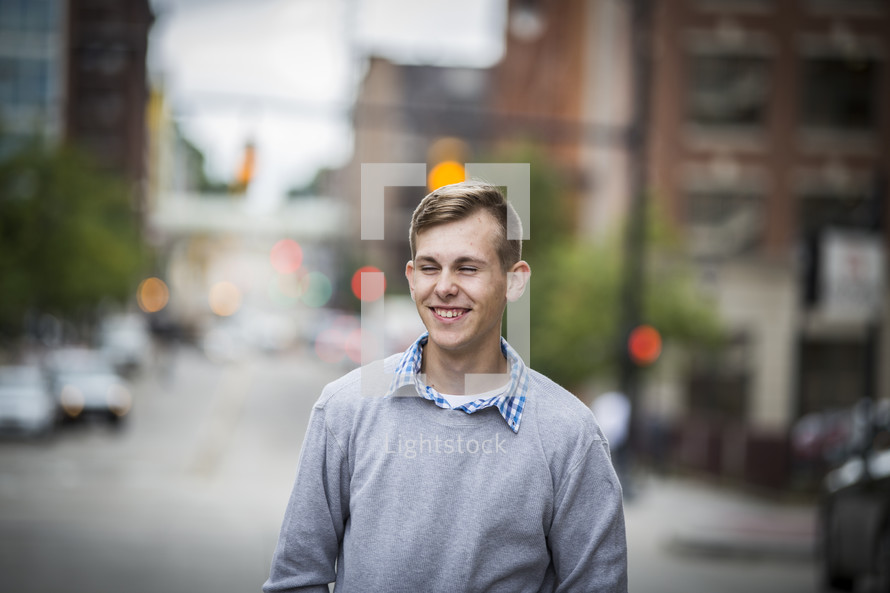 teen boy standing in the middle of a downtown street