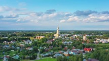 aerial view of a small village with a church tower in russia during a sunny day 4K