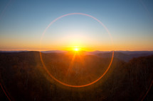 Lens flare makes a perfect sphere around the sun as it rises over the Monongahela National forest in West Virginia