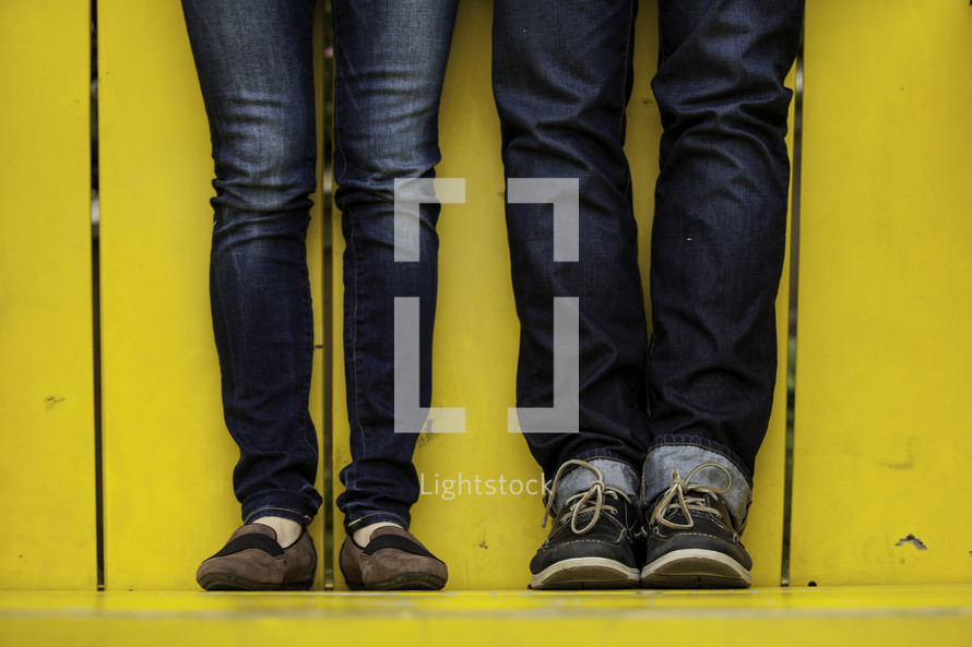 legs of a couple in jeans standing together 