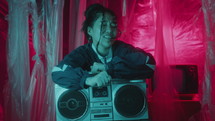 Vibey Asian Girl Dancing to Music on Boombox in Studio with Neon Light
