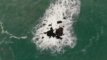 aerial view over rocks in a sea 
