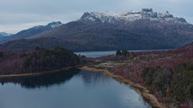 Drone shot of amazing lakes surrounded by lush forests, magnificent mountains with snow covered peaks in the background. National park landscape, scenic panorama of nature
