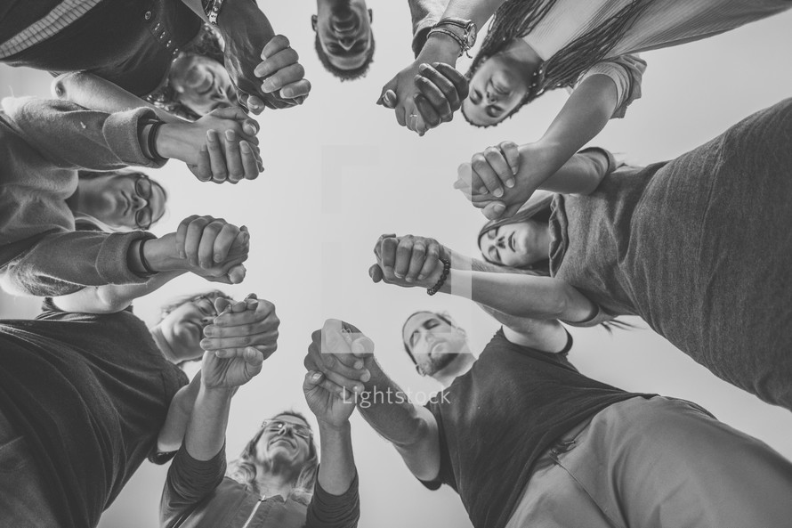 group holding hands in a prayer circle 