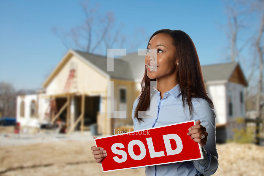 real estate agent holding a sold sign 
