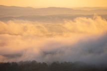 Foggy cloudy mist with sunrise glow over Grand Canyon mountains in Arkansas