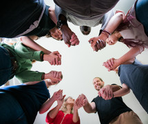group holding hands in a pray circle 