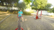 POV footage of three kids playing in a playground, running and climbing facilities.