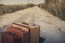 luggage on a dirt road 