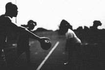 Silhouette of men playing football.