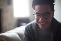 a man with a reading glasses and a smiling face 