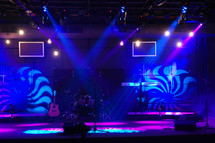 Lighted stage with musical instruments.