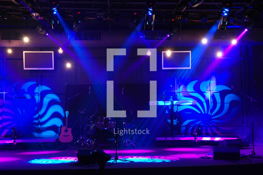 Lighted stage with musical instruments.