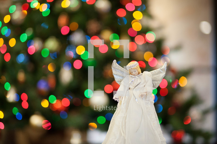 angel in front of a Christmas tree 