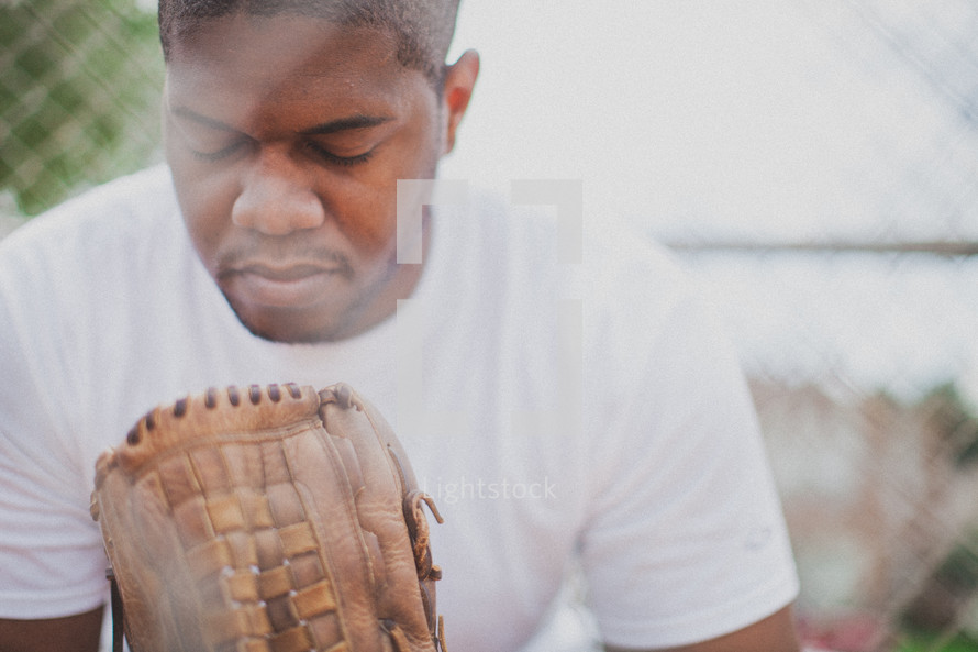 man in prayer in a baseball dugout 