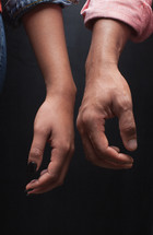 man and woman standing next to each other touching hands