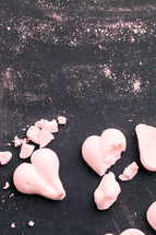 crumbs and pink heart shaped cookies 