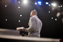 a man preaching at a pulpit with the Bible in his hands 