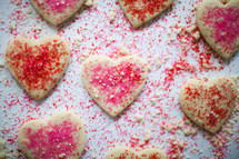 red and pink sprinkles on heart shaped cookies 