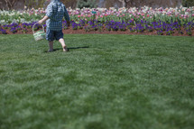 small boy with Easter basket in a garden of flowers
