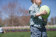 Young boy holding an oversized Easter egg