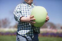 young boy holding a large Easter egg