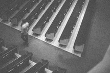man standing in the aisle of an empty church