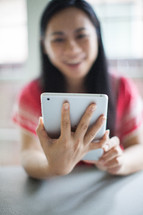 Asian woman looking at an iPad screen 