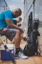 men praying in a baseball dugout 