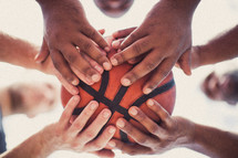 Players' hands holding a basketball.