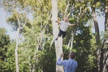 father tossing his son in the air