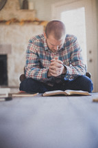 man praying over a Bible 