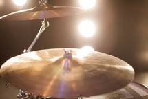 Stage lights shining on cymbals.