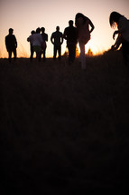 group of people walking outdoors at dusk 