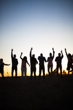 raised hands, praise, man, woman, silhouettes, group, people, row, standing, field, outdoors, worship 