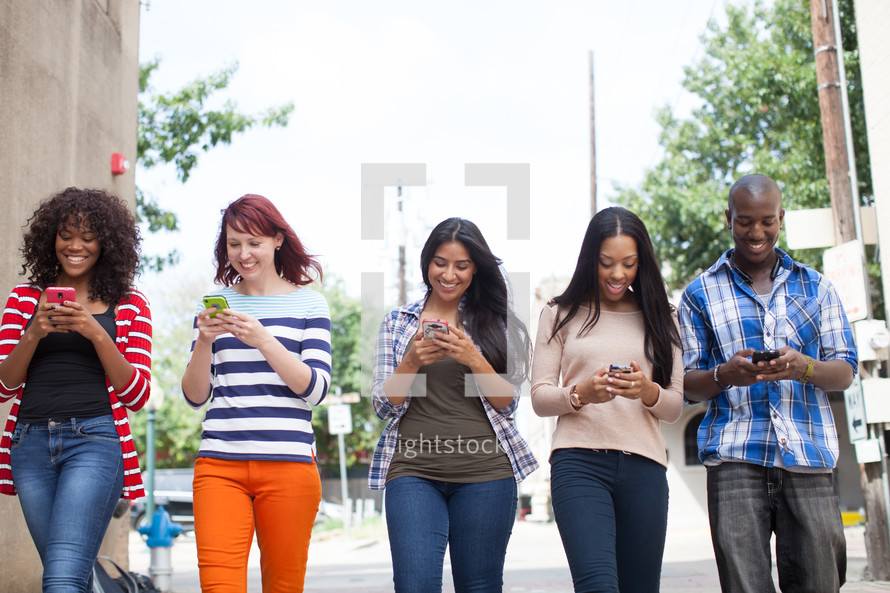 young adults walking and texting 
