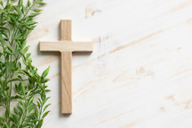 wood cross and green leaves 