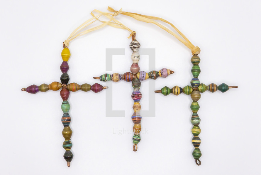 handmade paper bead and wire crosses made in Africa to support a missions ministry there, isolated on a white background