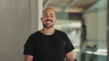 Hispanic bald handsome young man smiles at camera. Happy male human face friendly millennial 
