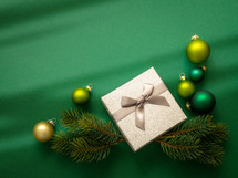Christmas ornaments and gift on green 