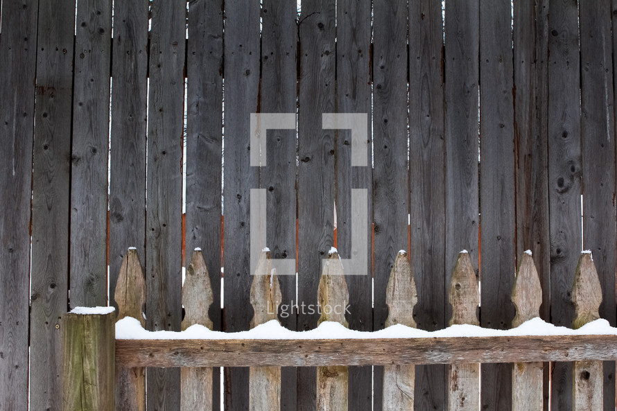 snow on a wooden fence 