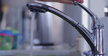 hand turns off water faucet- slow motion