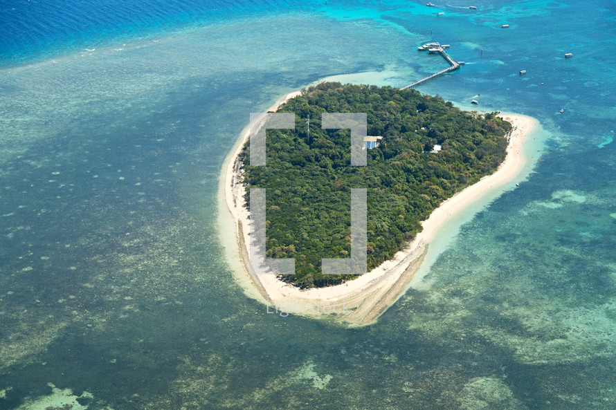 aerial view over an island and coral reef 