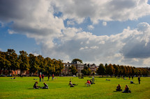 People enjoying  a day in a park of green grass.