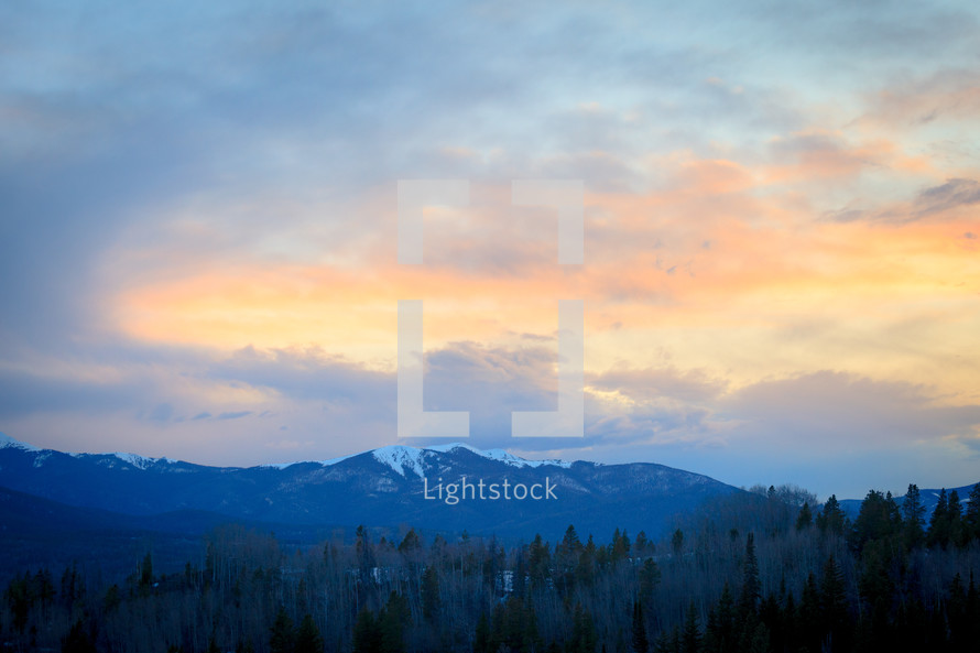 Snow capped mountain landscape at sunset near forest in Apraho National Forest, Colorado