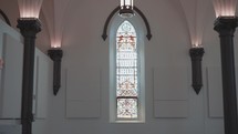 Looking at a stained glass window inside of a modern church.