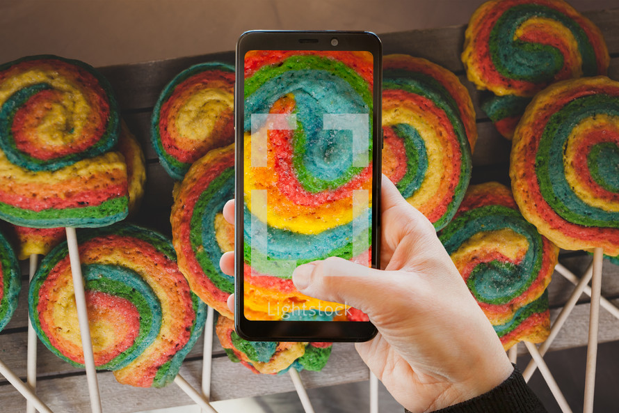 Using the camera with a mobile phone. Colorful pastry shaped like a pinwheel